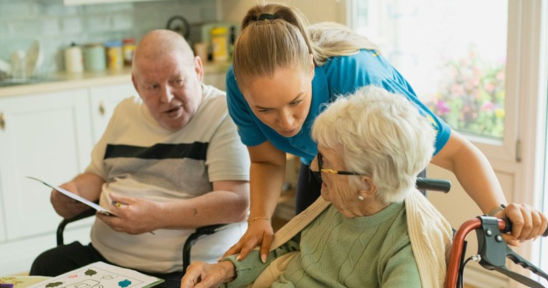 Caretaker helping an elderly couple with an activity before they fire her for doing her personal laundry at their home, using their washer and dryer, which drove up the water bill.