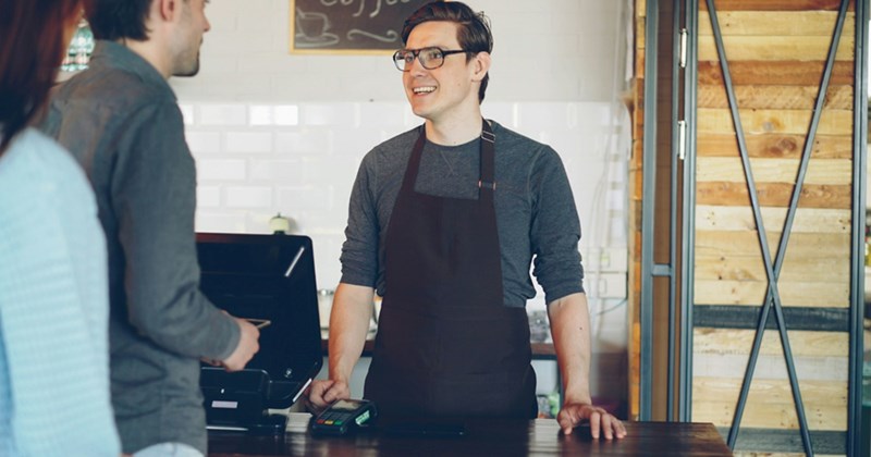A representation of a male cashier serving two customers
