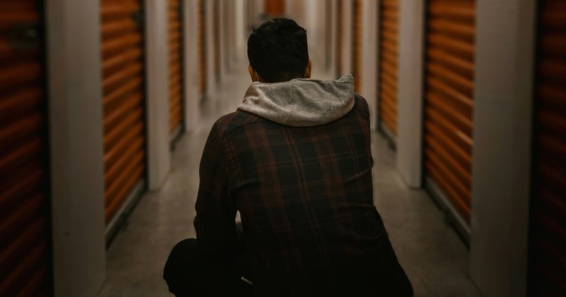 A model representing the back of a man crouching down in a hallway of a storage unit