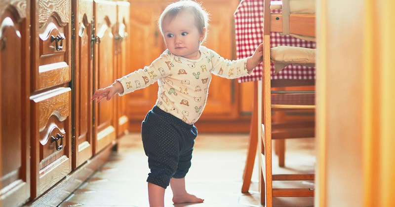 A baby takes his first steps while his father is at work, much to the chagrin of his mother, who doesn't want her husband to feel bad about missing out on milestones.