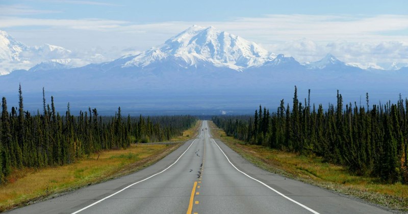 Empty road leading to snowy mountains