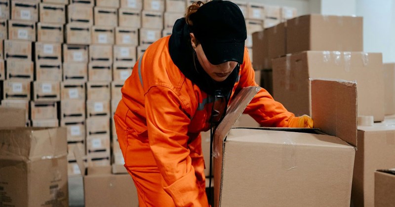 A person in an orange coverall and a black hat