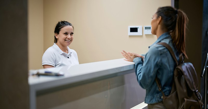 A medical receptionist talks to a patient