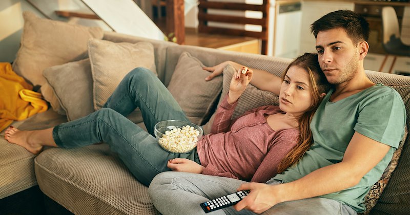 Boyfriend and girlfriend cuddling on the couch